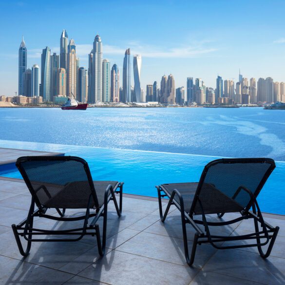 Infinity swimming pool in Dubai with city skyline view and blue sky